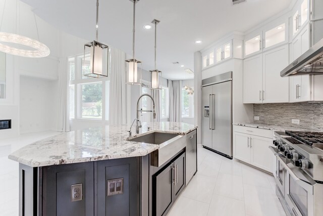 3650 Sage Hollow Dr, Spring, TX 77386 - kitchen with high end appliances, wall chimney range hood, a sink, white cabinetry, and recessed lighting