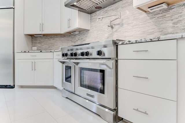 3650 Sage Hollow Dr, Spring, TX 77386 - kitchen featuring high quality appliances, light tile patterned floors, backsplash, white cabinetry, and light stone countertops
