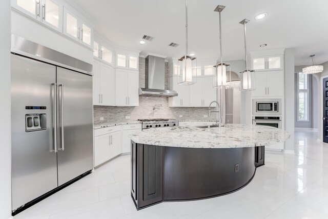 3650 Sage Hollow Dr, Spring, TX 77386 - kitchen with built in appliances, wall chimney range hood, decorative backsplash, an island with sink, and white cabinets