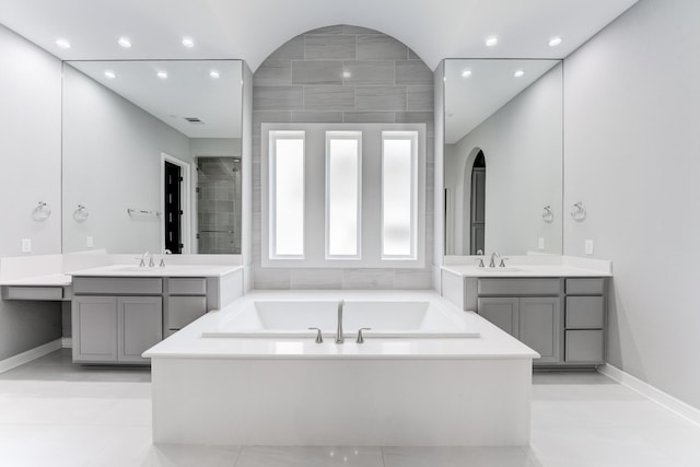 3650 Sage Hollow Dr, Spring, TX 77386 - bathroom featuring a garden tub, two vanities, recessed lighting, and baseboards