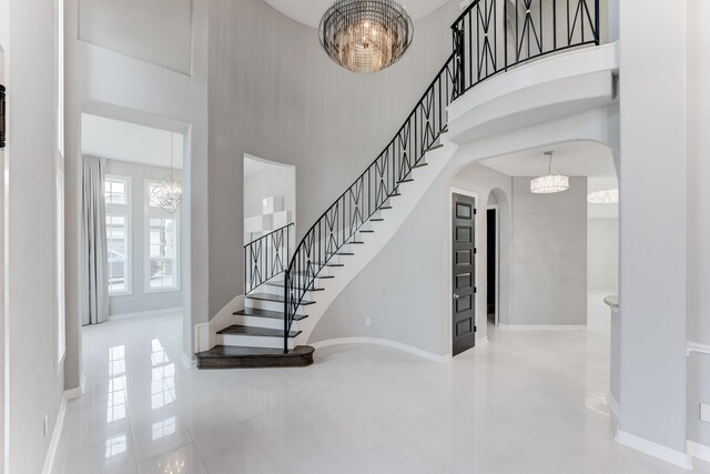 3650 Sage Hollow Dr, Spring, TX 77386 - tiled foyer entrance featuring arched walkways, stairs, a chandelier, a towering ceiling, and baseboards
