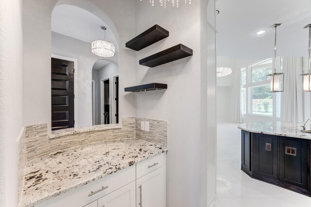 3650 Sage Hollow Dr, Spring, TX 77386 - bar area with arched walkways, backsplash, and hanging light fixtures