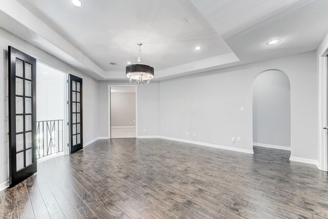 3650 Sage Hollow Dr, Spring, TX 77386 - spare room with a tray ceiling, arched walkways, baseboards, a chandelier, and recessed lighting