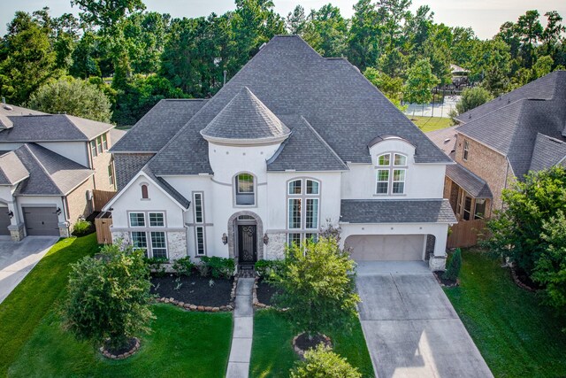 3650 Sage Hollow Dr, Spring, TX 77386 - french country inspired facade featuring stucco siding, a shingled roof, concrete driveway, and stone siding
