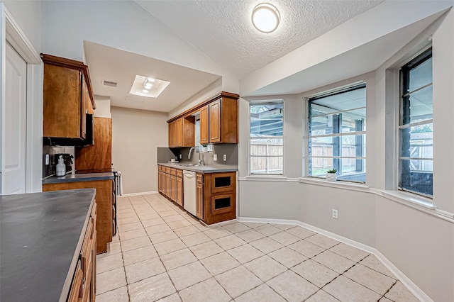 435 Coach Lamp Ln, Houston, TX 77060 - kitchen featuring dishwashing machine, light tile patterned floors, brown cabinetry, a sink, and a textured ceiling
