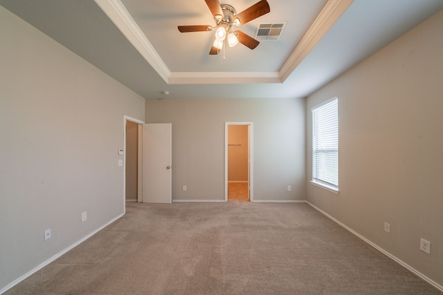 16414 Peyton Stone Cir, Houston, TX 77049 - unfurnished bedroom featuring a tray ceiling, a walk in closet, ornamental molding, carpet floors, and baseboards