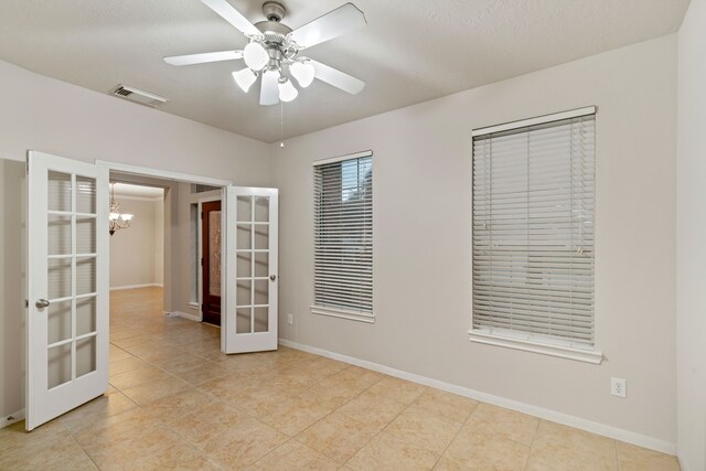 17426 Memorial Blossom Dr, Spring, TX 77379 - tiled empty room featuring french doors, baseboards, a ceiling fan, and a chandelier