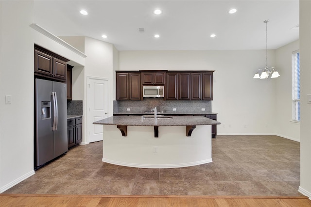 10938 Glenrothers Dr, Richmond, TX 77407 - kitchen featuring appliances with stainless steel finishes, decorative backsplash, a chandelier, dark brown cabinetry, and recessed lighting