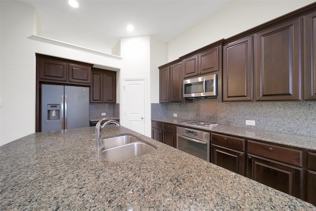 10938 Glenrothers Dr, Richmond, TX 77407 - kitchen with appliances with stainless steel finishes, dark brown cabinetry, tasteful backsplash, stone countertops, and recessed lighting