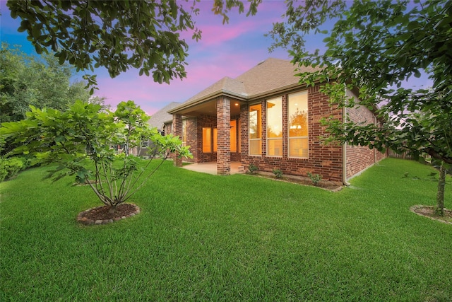 10938 Glenrothers Dr, Richmond, TX 77407 - view of front of house with brick siding, a lawn, a patio, and a shingled roof