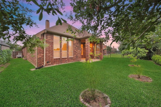 10938 Glenrothers Dr, Richmond, TX 77407 - back of house at dusk with brick siding and a chimney