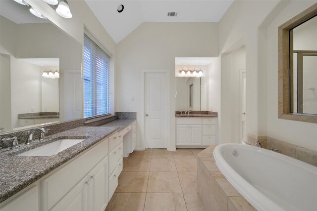 10938 Glenrothers Dr, Richmond, TX 77407 - bathroom featuring a garden tub, two vanities, vaulted ceiling, and tile patterned floors