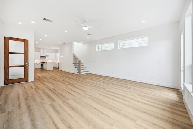 1212 Nadine St, Houston, TX 77009 - unfurnished living room featuring stairs, light wood-style floors, baseboards, a ceiling fan, and recessed lighting
