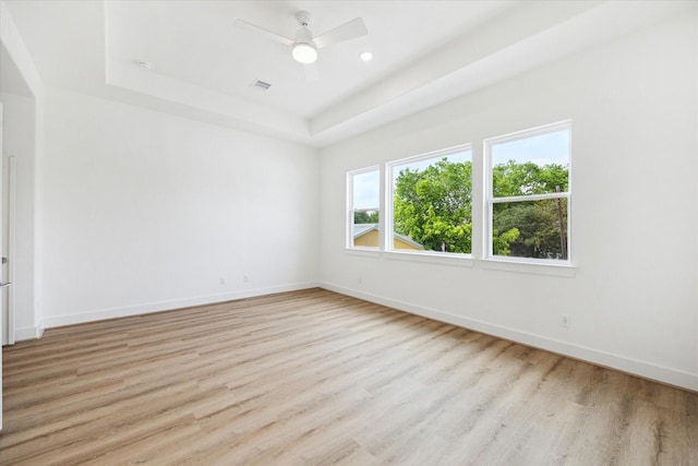 1212 Nadine St, Houston, TX 77009 - empty room featuring a raised ceiling, light wood-type flooring, baseboards, and a ceiling fan