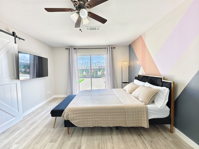 11810 Sagedowne Ln, Houston, TX 77089 - bedroom with a barn door, access to exterior, baseboards, and wood finished floors
