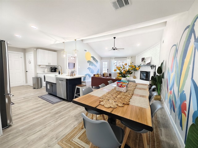 11810 Sagedowne Ln, Houston, TX 77089 - dining area featuring light wood finished floors, a brick fireplace, baseboards, a chandelier, and a ceiling fan