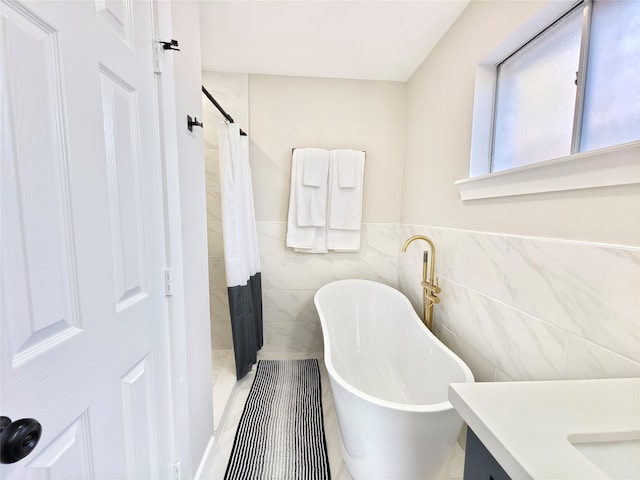 11810 Sagedowne Ln, Houston, TX 77089 - bathroom featuring tile walls, a shower with shower curtain, vanity, a soaking tub, and a wainscoted wall