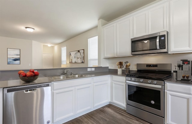 25323 Merino Dr, Magnolia, TX 77355 - kitchen featuring stainless steel appliances, a sink, white cabinetry, a peninsula, and dark wood-type flooring