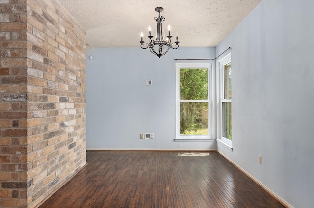 414 Enfield Dr, Highlands, TX 77562 - empty room featuring a textured ceiling, a chandelier, dark wood-type flooring, and baseboards