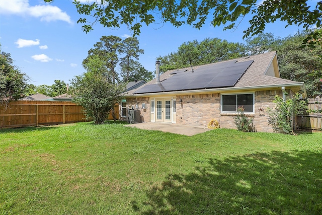 414 Enfield Dr, Highlands, TX 77562 - back of property with french doors, roof mounted solar panels, a patio area, and roof with shingles