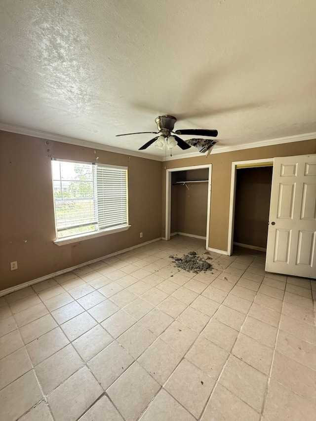 15125 S Dr, Channelview, TX 77530 - unfurnished bedroom with ornamental molding, two closets, baseboards, light tile patterned floors, and a textured ceiling
