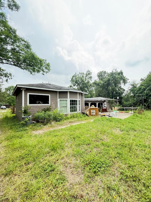 15125 S Dr, Channelview, TX 77530 - rear view of property featuring a lawn