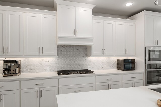 1918 Longcroft Ln, Katy, TX 77493 - kitchen with appliances with stainless steel finishes, white cabinets, light countertops, tasteful backsplash, and premium range hood
