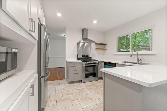 28 Silver Elm Pl, The Woodlands, TX 77381 - kitchen featuring wall chimney range hood, stainless steel appliances, a sink, gray cabinetry, and tasteful backsplash