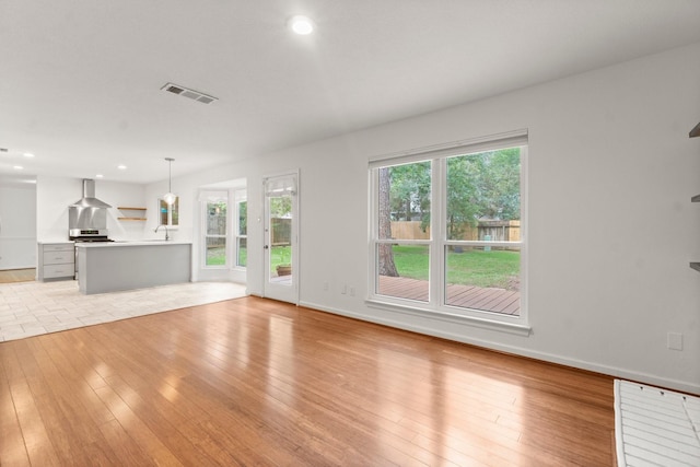 28 Silver Elm Pl, The Woodlands, TX 77381 - unfurnished living room with light wood-type flooring, baseboards, recessed lighting, and a sink