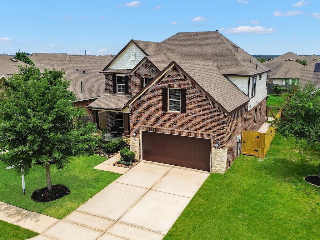 24618 Ballad Dr, Katy, TX 77493 - view of front of property with stone siding, brick siding, an attached garage, roof with shingles, and driveway