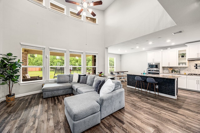 14121 N Lake Branch Ln, Houston, TX 77044 - living area with dark wood finished floors, a ceiling fan, baseboards, a towering ceiling, and recessed lighting