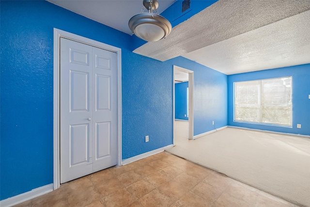 8100 Creekbend Dr Unit 146, Houston, TX 77071 - unfurnished bedroom featuring a textured wall, baseboards, a textured ceiling, and carpet