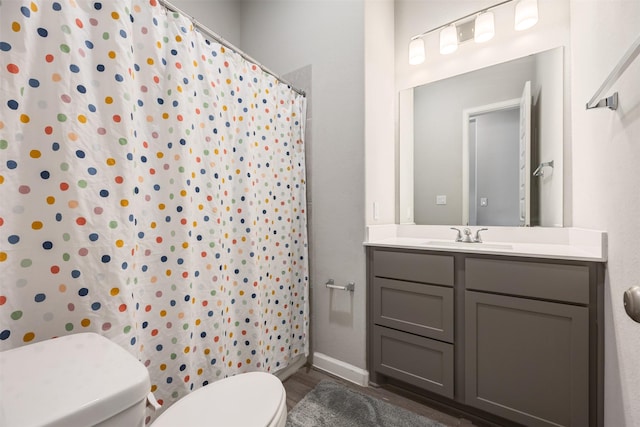10522 Rigel Ridge Way, Richmond, TX 77406 - bathroom with toilet, vanity, wood finished floors, curtained shower, and baseboards