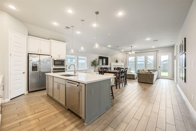 10522 Rigel Ridge Way, Richmond, TX 77406 - kitchen with appliances with stainless steel finishes, a sink, gray cabinetry, light wood-style floors, and a ceiling fan