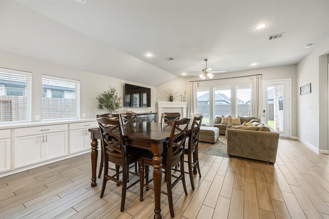 10522 Rigel Ridge Way, Richmond, TX 77406 - dining room with light wood-style flooring, a fireplace, ceiling fan, lofted ceiling, and recessed lighting
