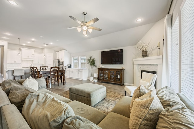 10522 Rigel Ridge Way, Richmond, TX 77406 - living room featuring ceiling fan, a fireplace, light wood-style floors, lofted ceiling, and recessed lighting