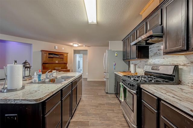2026 Naplechase Crest Dr, Spring, TX 77373 - kitchen featuring stainless steel appliances, range hood, a sink, light countertops, and light wood-type flooring