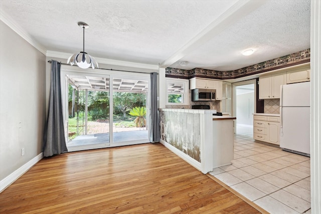 7658 El Rancho St, Houston, TX 77087 - kitchen featuring freestanding refrigerator, stainless steel microwave, a textured ceiling, range, and crown molding