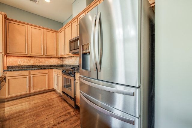 2915 Pease St, Houston, TX 77003 - kitchen featuring appliances with stainless steel finishes, backsplash, light wood-type flooring, light brown cabinets, and recessed lighting