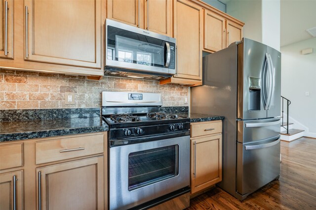 2915 Pease St, Houston, TX 77003 - kitchen with stainless steel appliances, dark wood-type flooring, dark countertops, backsplash, and light brown cabinetry