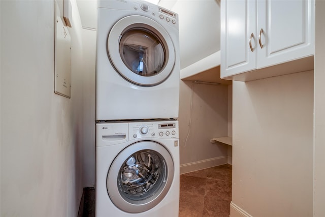 2915 Pease St, Houston, TX 77003 - laundry area with stacked washing machine and dryer, baseboards, and cabinet space