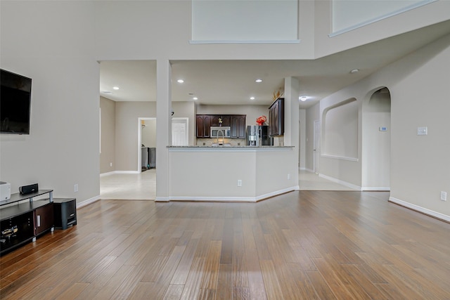 4114 Elk Bluff Ln, Katy, TX 77494 - unfurnished living room with wood finished floors, recessed lighting, baseboards, and arched walkways