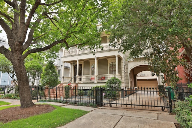 1132 Oxford St, Houston, TX 77008 - view of front facade with a balcony, driveway, covered porch, a fenced front yard, and a garage