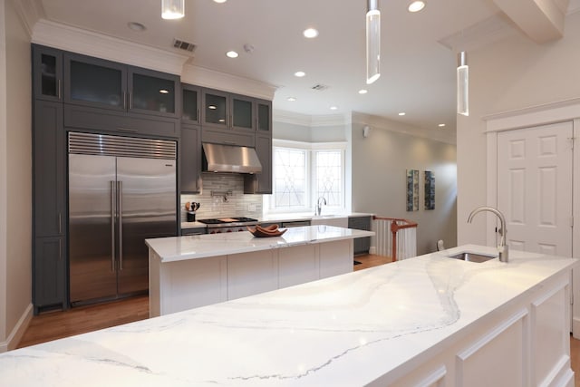1132 Oxford St, Houston, TX 77008 - kitchen with stainless steel built in fridge, a kitchen island, under cabinet range hood, a sink, and crown molding