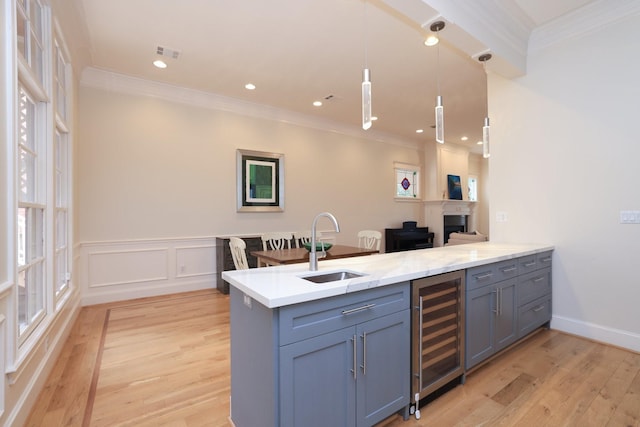 1132 Oxford St, Houston, TX 77008 - kitchen with beverage cooler, crown molding, a sink, a peninsula, and light wood-type flooring