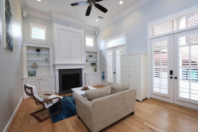 1132 Oxford St, Houston, TX 77008 - living room featuring french doors, a large fireplace, crown molding, light wood-style flooring, and healthy amount of natural light
