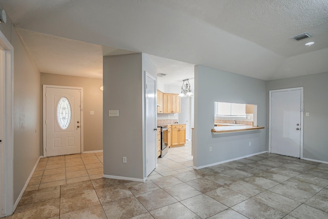 5902 Yorkgate Dr, Spring, TX 77373 - foyer entrance featuring light tile patterned flooring, baseboards, a chandelier, and a textured ceiling