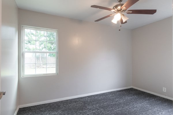 3322 Mccrarey Dr, Houston, TX 77088 - empty room with dark colored carpet, a ceiling fan, and baseboards