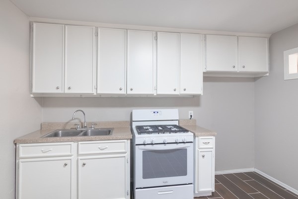 3322 Mccrarey Dr, Houston, TX 77088 - kitchen with white gas range oven, a sink, light countertops, and white cabinetry