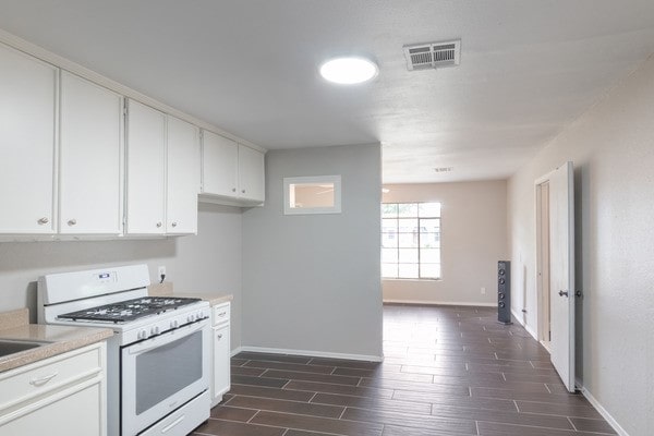 3322 Mccrarey Dr, Houston, TX 77088 - kitchen with white range with gas stovetop, baseboards, and wood tiled floors